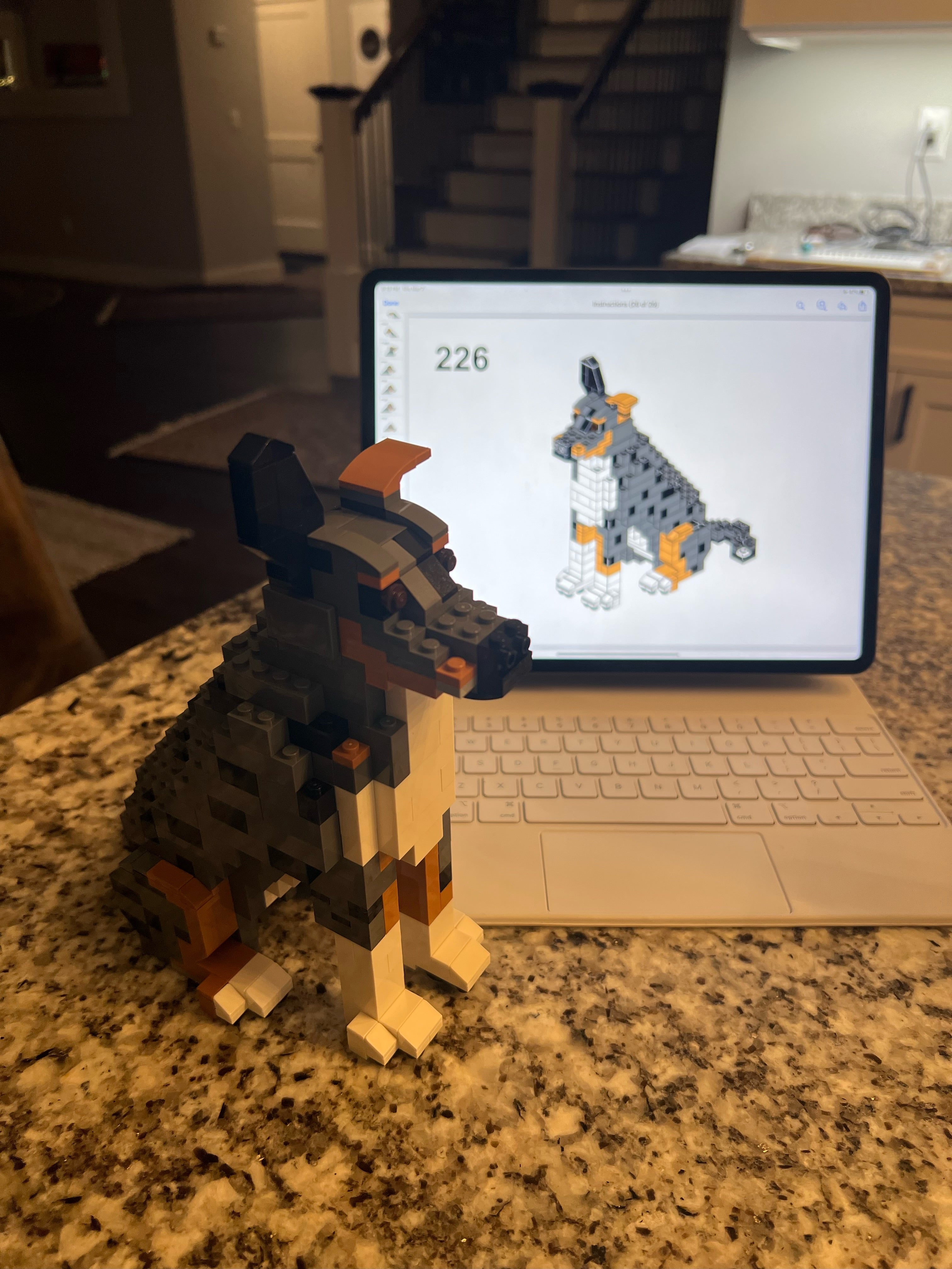 Custom brick dog next to the 3D design on a laptop